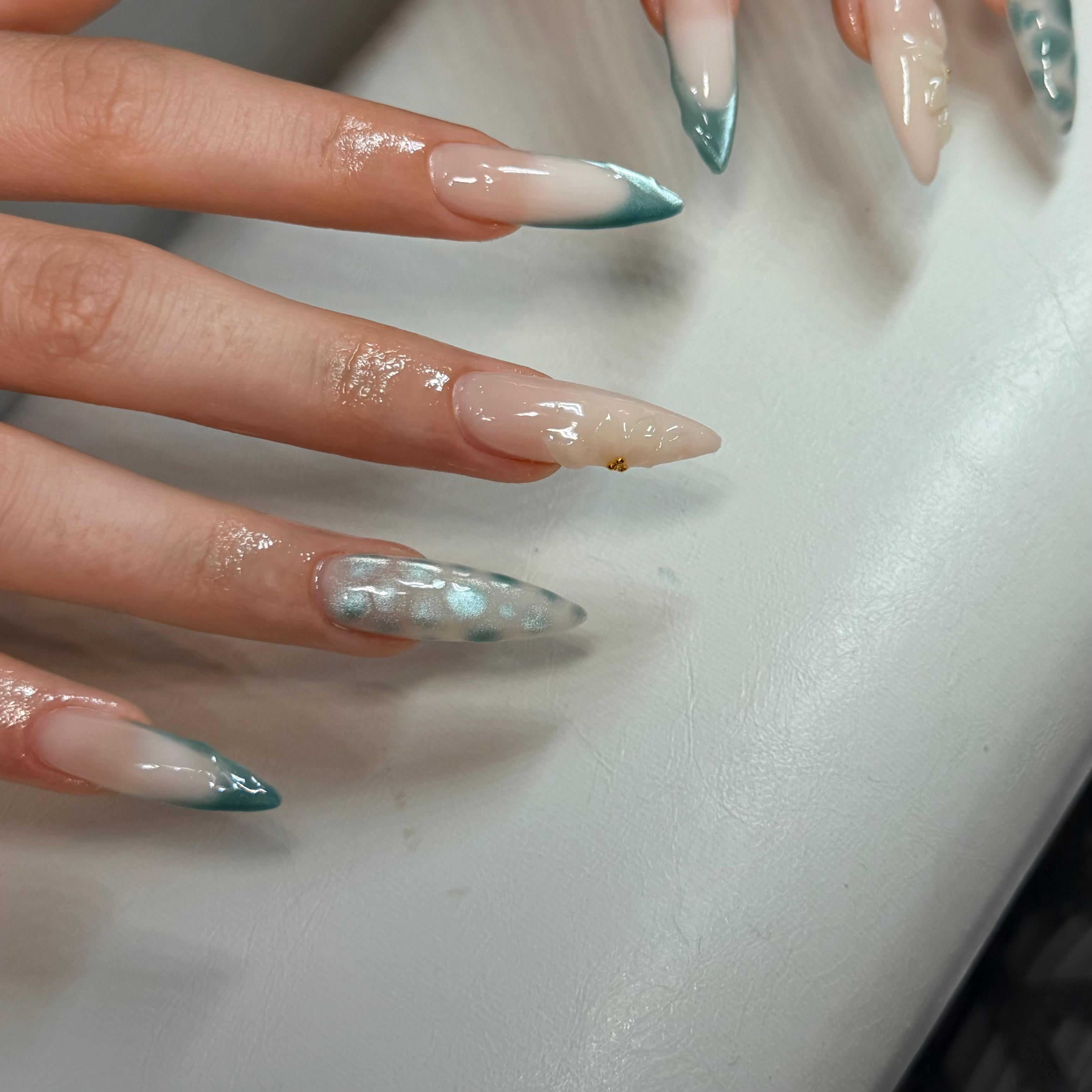 Gel-Nägel Schwechat – Teal Chrome Ombre Stiletto auf weißer Oberfläche